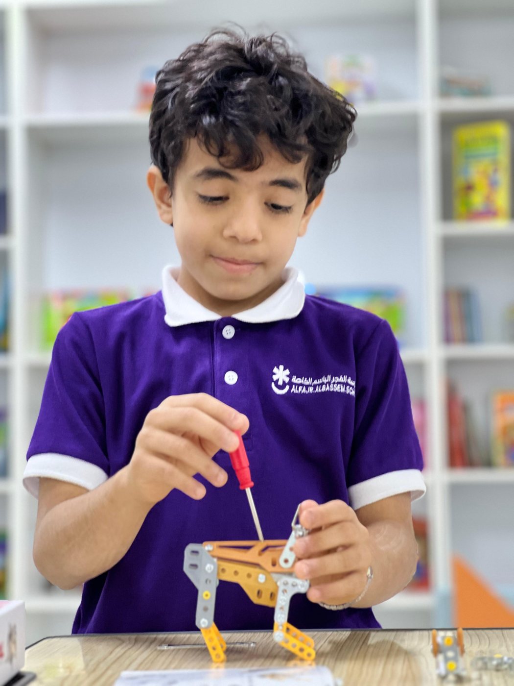 طالب يركّب مجسّمًا هندسيًا في المكتبة