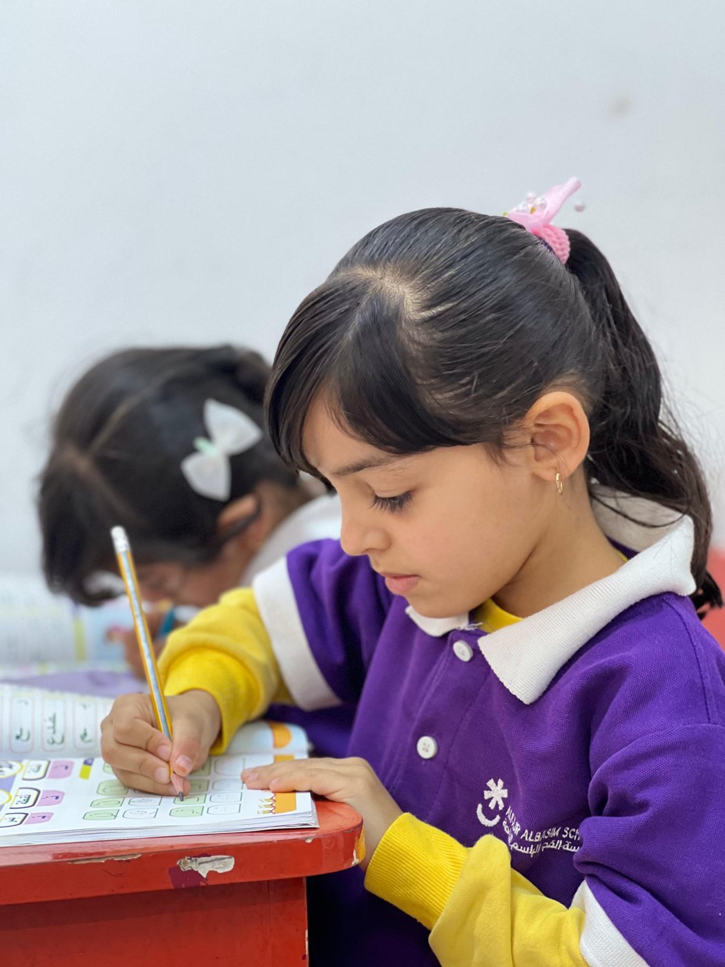 طالبة تكتب في حصة اللغة العربية