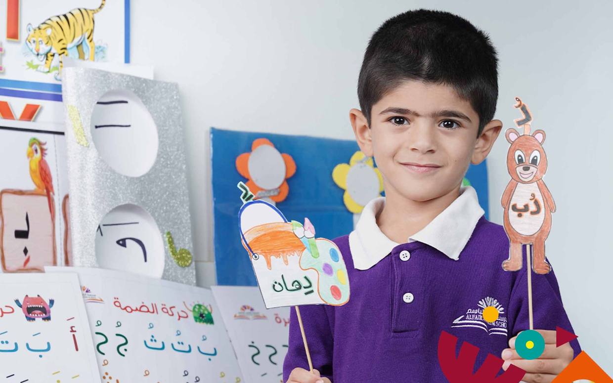 طالب يعرض بطاقات الحروف العربية داخل الفصل